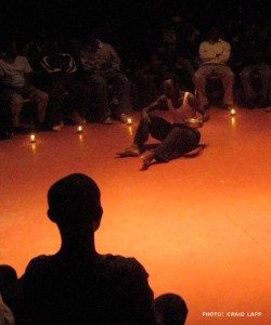 A performer acting out a candlelit scene from The Monument, a play directed by Capraru.  (Courtesy)