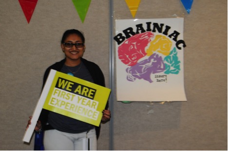 Davi Lall, who is part of the First Year Experience (FYE) team, stands in front of the popular “Brainiac” game. FYE helps new students on campus a number of welcome-oriented events and helps connect freshmen to peer mentors.