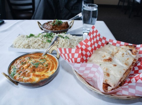 Delicious indian food and naan bread on a dinner table.